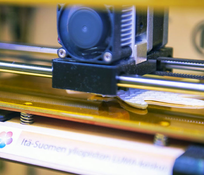 3D-tulostin tulostaa valkoista kappaletta.